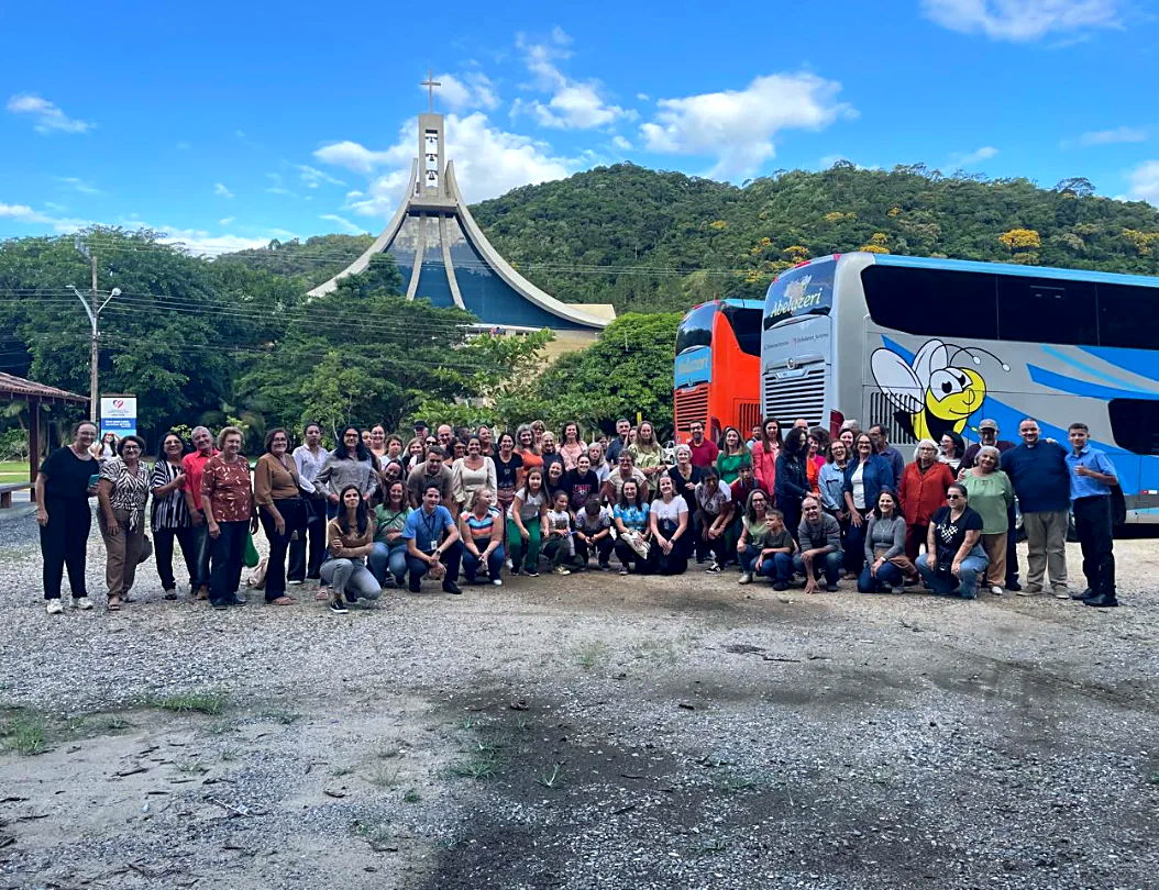 Grupo de passageiros da Abelazeri em frente aos ônibus, numa romaria