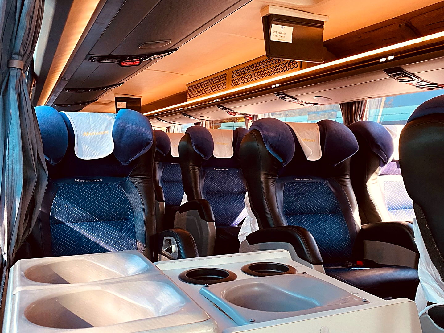 Salão do ônibus visto do fundo, com porta-copos em primeiro plano